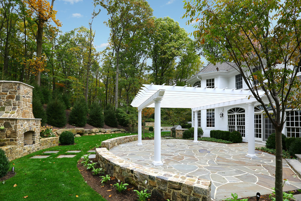 Patio - large traditional backyard stone patio idea in New York with a fire pit and a pergola