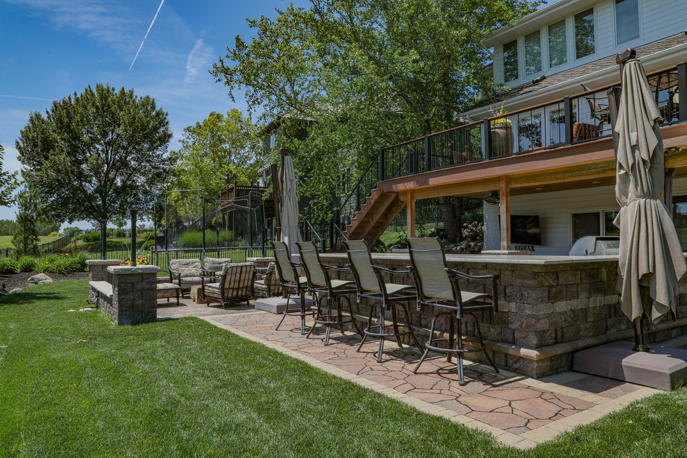 Réalisation d'une terrasse arrière design de taille moyenne avec une cuisine d'été et des pavés en béton.