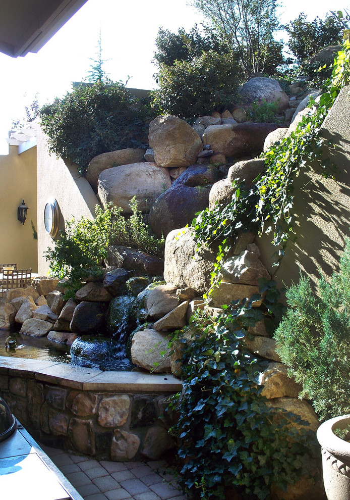 Photo of a small back patio in Phoenix with a living wall and brick paving.