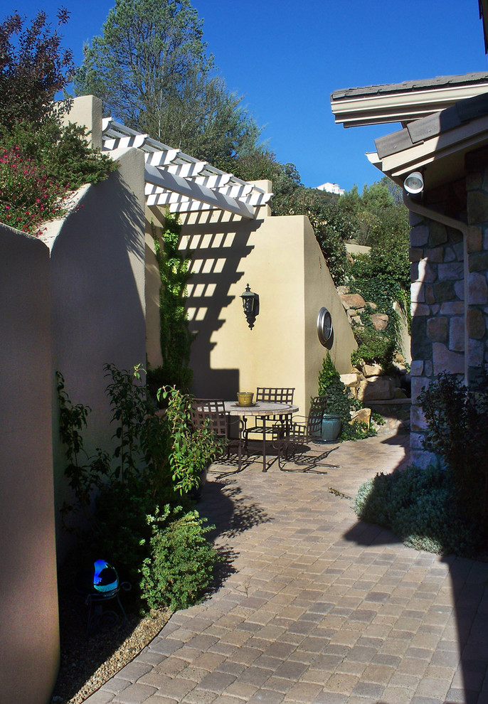 This is an example of a small back patio in Phoenix with a living wall and brick paving.