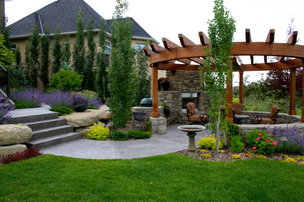 Esempio di un patio o portico minimalista di medie dimensioni e dietro casa con pavimentazioni in cemento, un focolare e una pergola