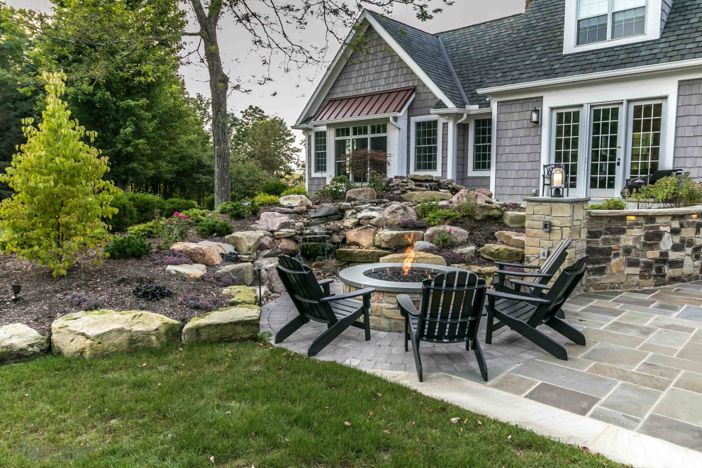 Diseño de patio clásico de tamaño medio sin cubierta en patio trasero con brasero y adoquines de piedra natural
