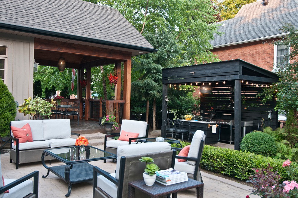 Inspiration for a mid-sized transitional backyard concrete paver patio kitchen remodel in Toronto with a roof extension