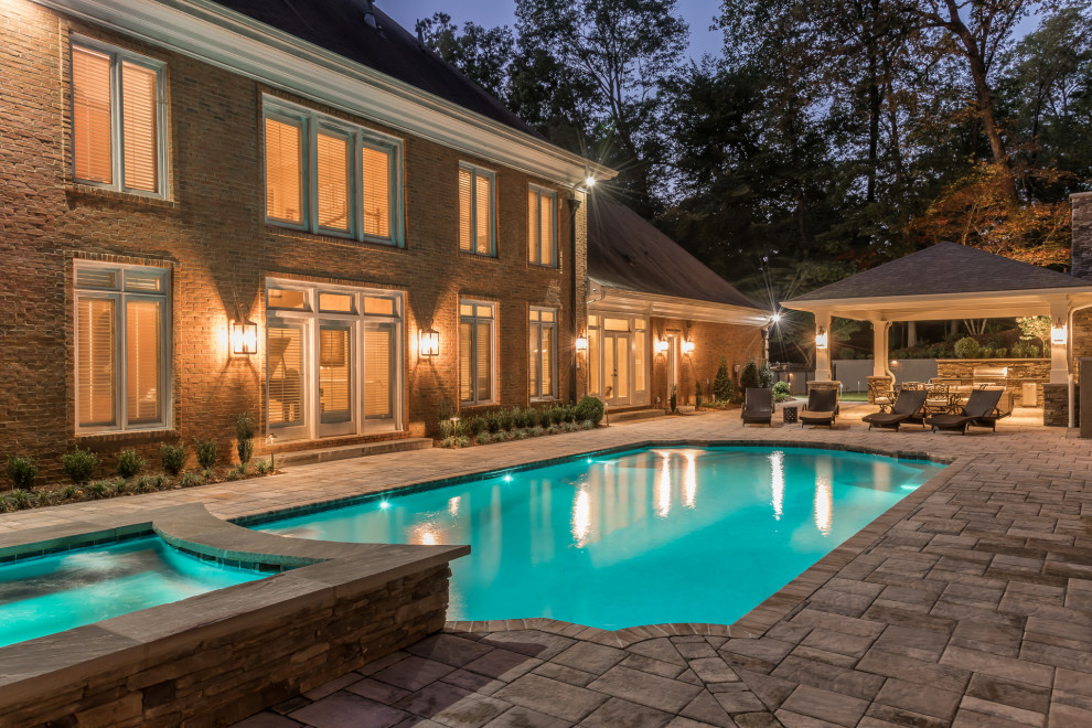 Photo of an expansive traditional back patio in Atlanta with an outdoor kitchen, natural stone paving and a gazebo.