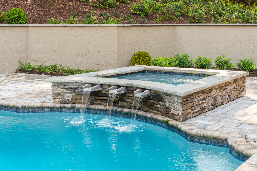Diseño de piscina clásica extra grande en patio trasero con adoquines de piedra natural