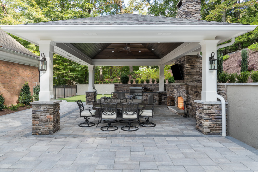 Esempio di un ampio patio o portico classico dietro casa con pavimentazioni in pietra naturale e un gazebo o capanno