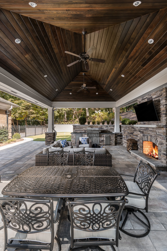 Diseño de patio clásico extra grande en patio trasero con cocina exterior, adoquines de piedra natural y cenador