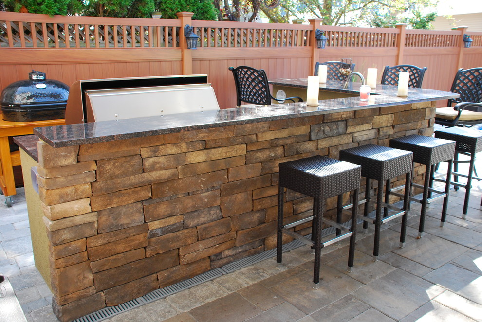 Patio kitchen - large coastal backyard concrete paver patio kitchen idea in New York with a roof extension