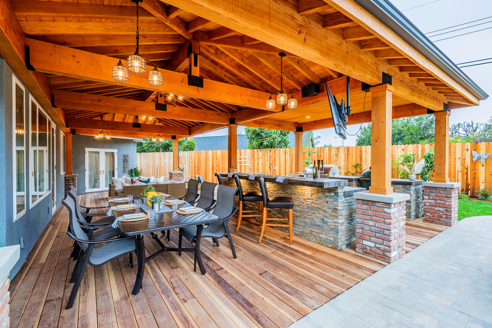 Inspiration for a large rustic back patio in Orange County with an outdoor kitchen, decking and a roof extension.