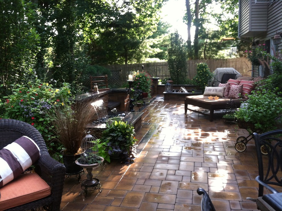 На фото: двор на заднем дворе в стиле модернизм с мощением тротуарной плиткой и местом для костра