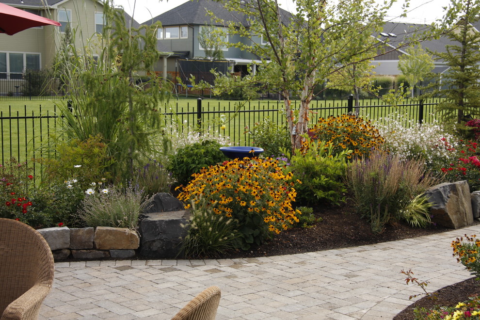 Diseño de jardín rústico de tamaño medio en patio trasero con adoquines de piedra natural