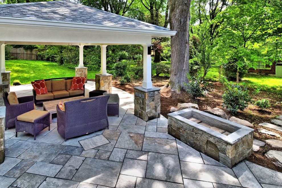 Immagine di un patio o portico minimalista di medie dimensioni e dietro casa con un focolare, pavimentazioni in pietra naturale e un gazebo o capanno