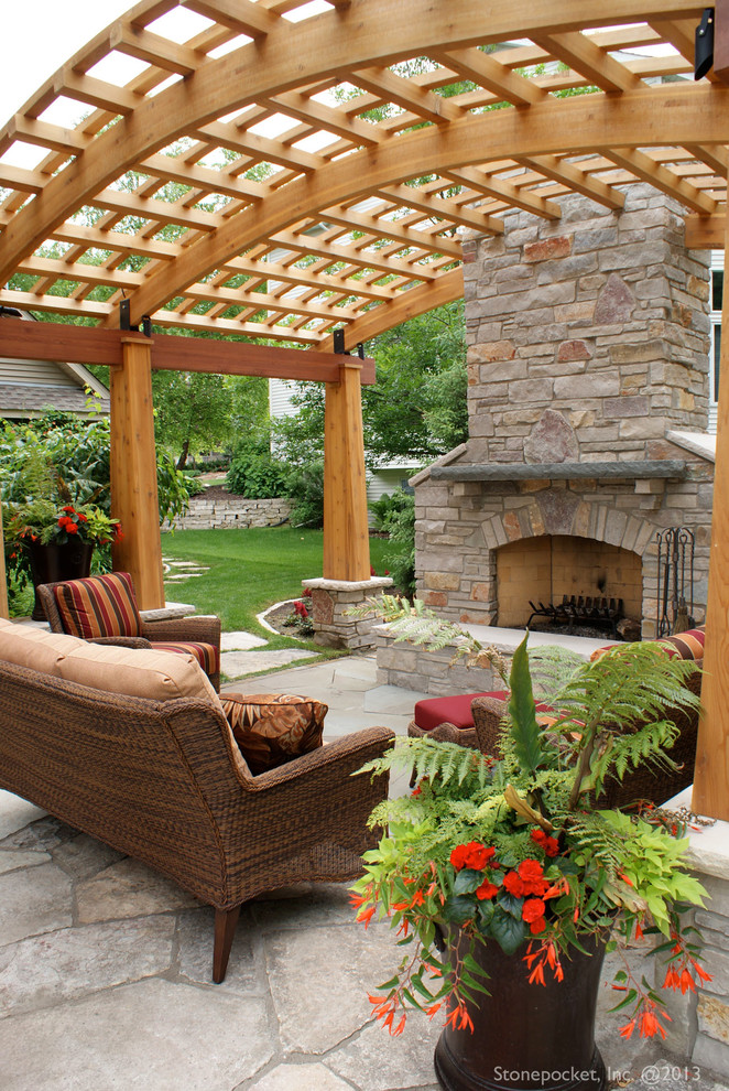 Foto di un patio o portico classico di medie dimensioni e dietro casa con pavimentazioni in pietra naturale e una pergola