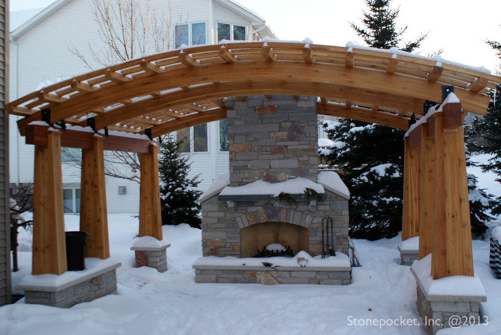 Patio - mid-sized traditional backyard stone patio idea in Minneapolis with a pergola