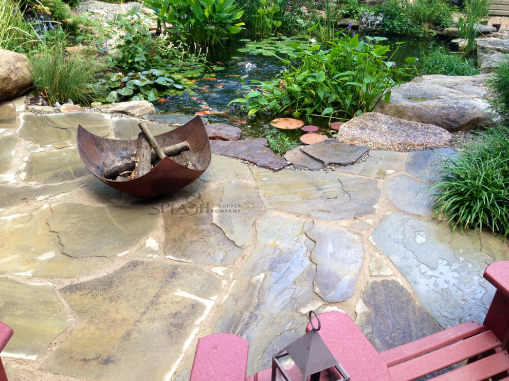 Diseño de patio rústico de tamaño medio en patio trasero con fuente, adoquines de piedra natural y pérgola