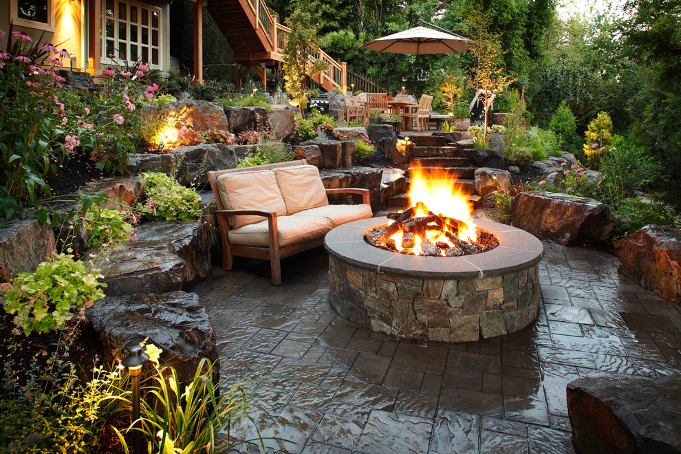 Inspiration for a large timeless backyard stone patio remodel in Seattle with a fire pit and no cover