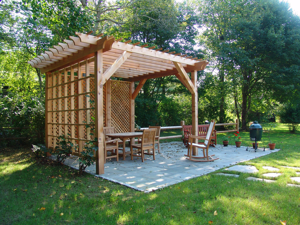 Diseño de patio clásico de tamaño medio en patio trasero con jardín vertical, adoquines de piedra natural y pérgola