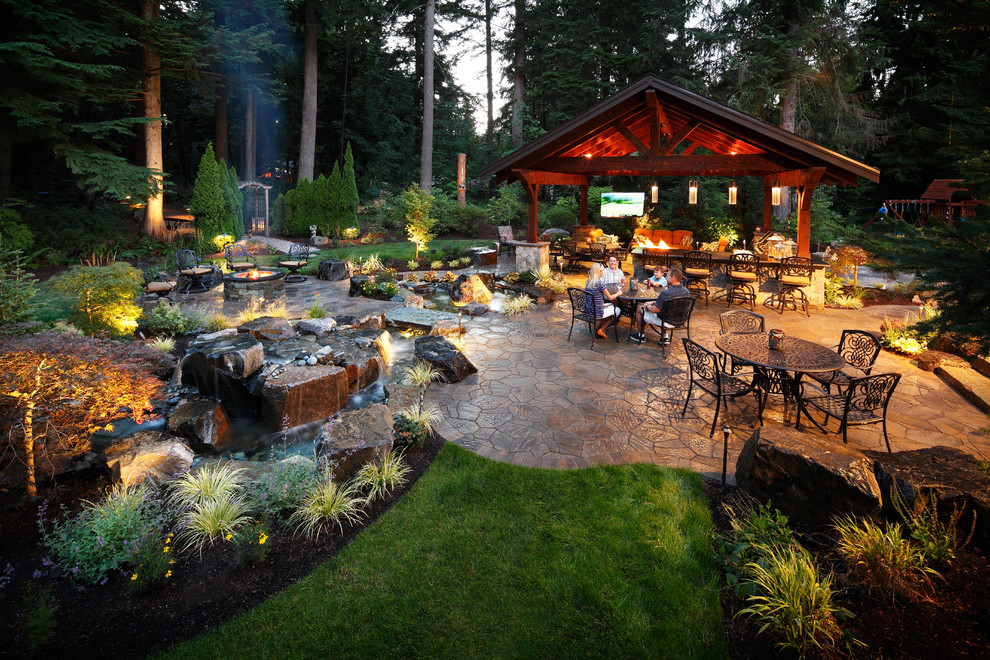 Photo of a large traditional back patio in Seattle with a water feature, natural stone paving and a gazebo.