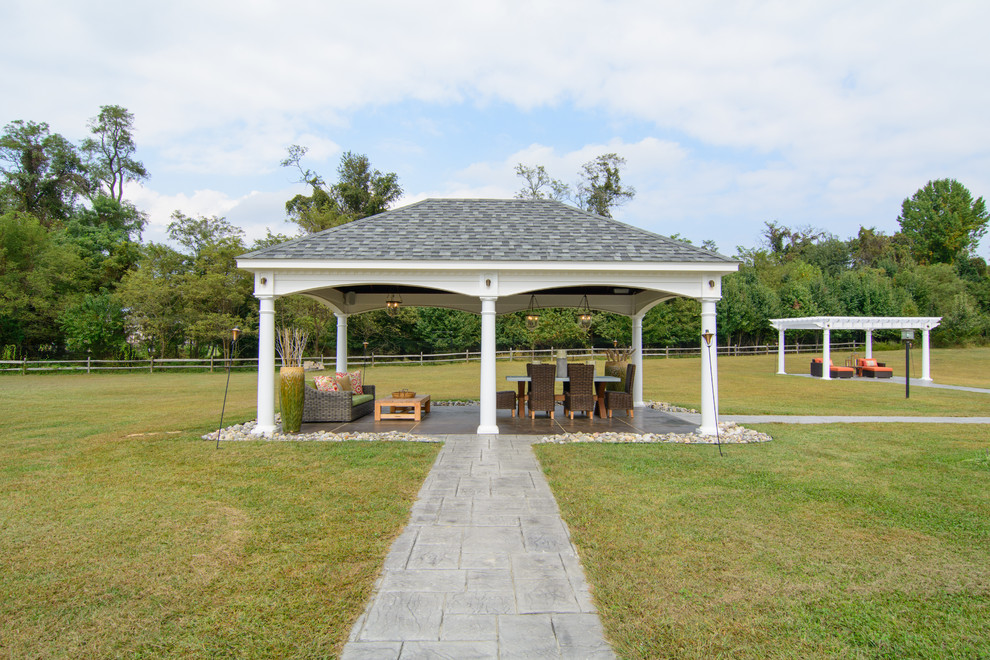Esempio di un ampio patio o portico tradizionale dietro casa con cemento stampato e una pergola