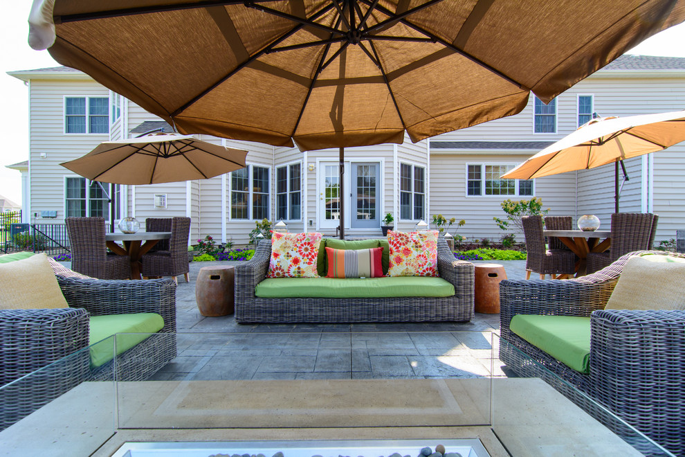 Foto di un ampio patio o portico classico dietro casa con cemento stampato e una pergola