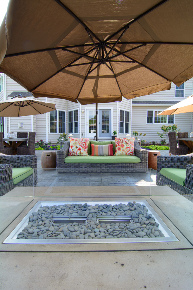 Idee per un ampio patio o portico classico dietro casa con cemento stampato e una pergola