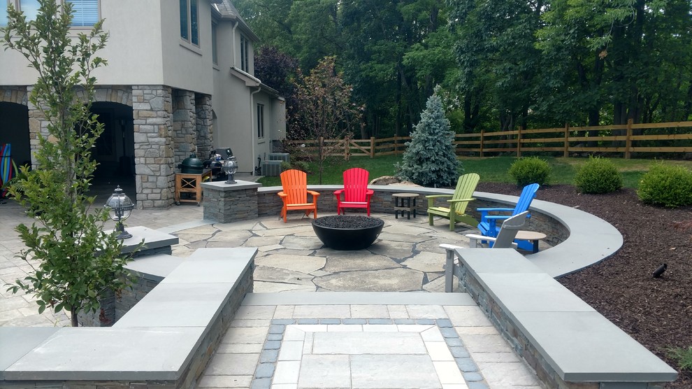 Inspiration for a mid-sized transitional backyard stone patio remodel in Philadelphia with a fire pit and no cover