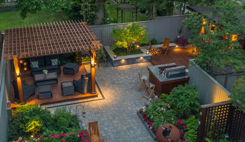Inspiration pour une terrasse arrière design de taille moyenne avec une cuisine d'été, des pavés en pierre naturelle et une pergola.