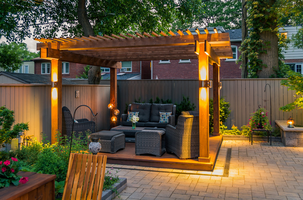 Mid-sized trendy backyard stone patio kitchen photo in Toronto with a pergola