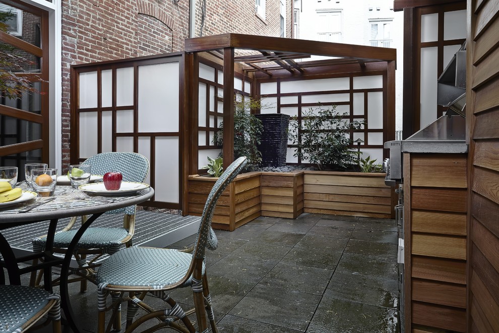 Immagine di un patio o portico etnico di medie dimensioni e dietro casa con pavimentazioni in cemento e una pergola