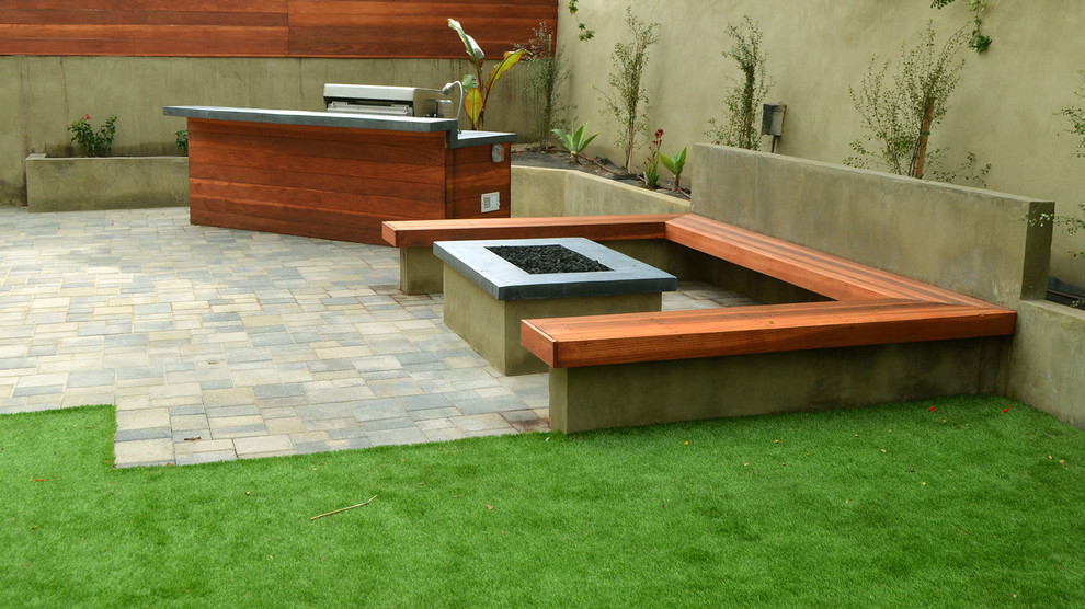 Patio - large modern backyard stone patio idea in Los Angeles with a fire pit and no cover