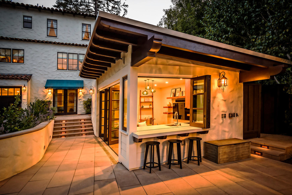 Diseño de patio de estilo americano en patio trasero y anexo de casas con cocina exterior y adoquines de hormigón