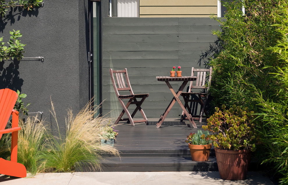 Пример оригинального дизайна: маленький двор на боковом дворе в современном стиле с растениями в контейнерах и настилом без защиты от солнца для на участке и в саду