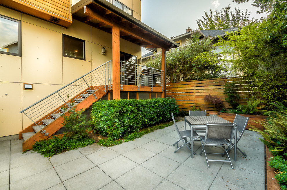 Ispirazione per un patio o portico contemporaneo di medie dimensioni e dietro casa con pavimentazioni in cemento e nessuna copertura