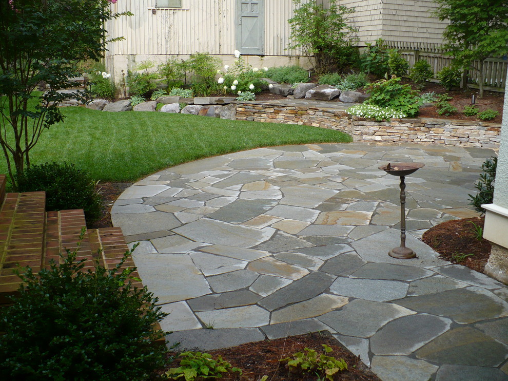 This is an example of a medium sized rustic back patio in Baltimore with natural stone paving.