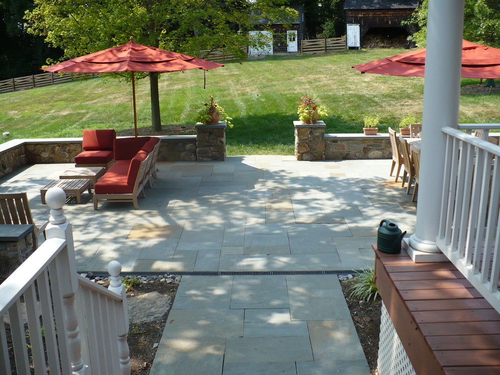 Immagine di un grande patio o portico tradizionale dietro casa con pavimentazioni in pietra naturale