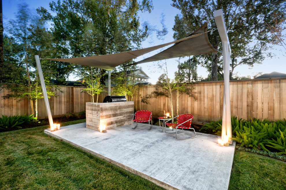 Foto di un patio o portico minimal dietro casa con pedane e un parasole