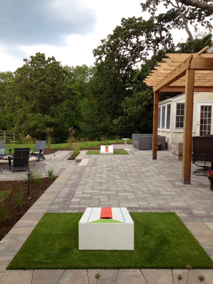 Example of a large trendy backyard brick patio design in Chicago with a fire pit and a pergola