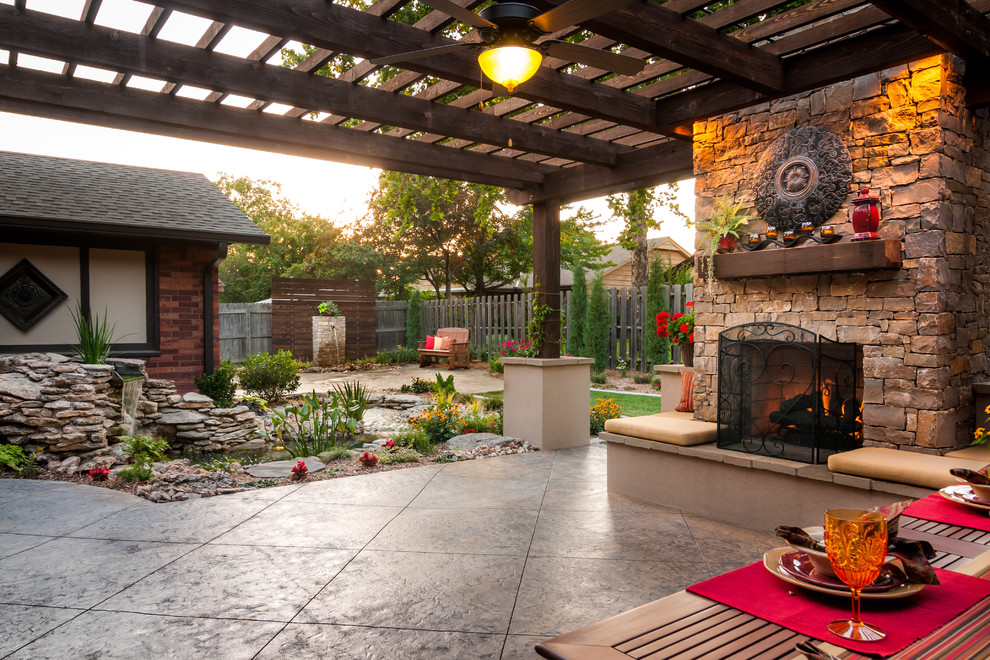 Modelo de patio clásico de tamaño medio en patio trasero con brasero, adoquines de piedra natural y pérgola