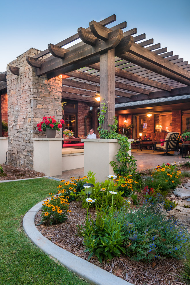 Mid-sized elegant backyard stone patio photo in Oklahoma City with a fire pit and a pergola