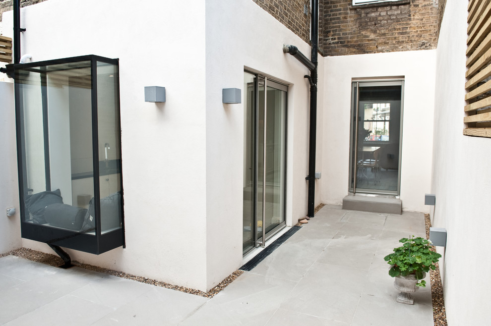 На фото: двор среднего размера на заднем дворе в современном стиле с мощением тротуарной плиткой без защиты от солнца с