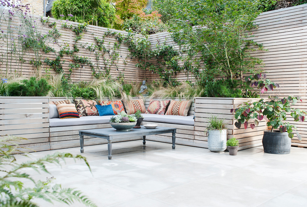 Foto di un piccolo patio o portico eclettico con un giardino in vaso e pavimentazioni in pietra naturale