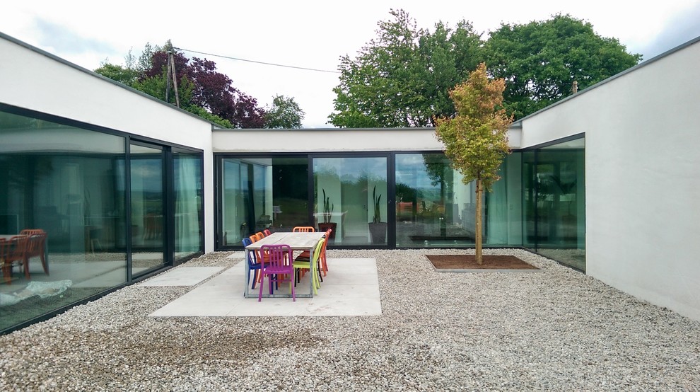 Ispirazione per un ampio patio o portico moderno in cortile con ghiaia e nessuna copertura