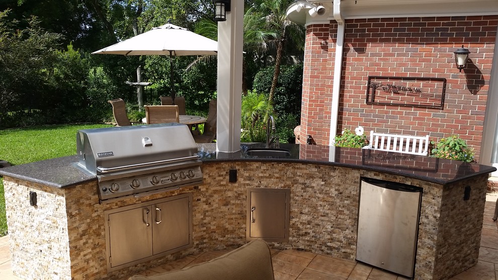 Large mediterranean back patio in Houston with an outdoor kitchen, concrete slabs and a pergola.