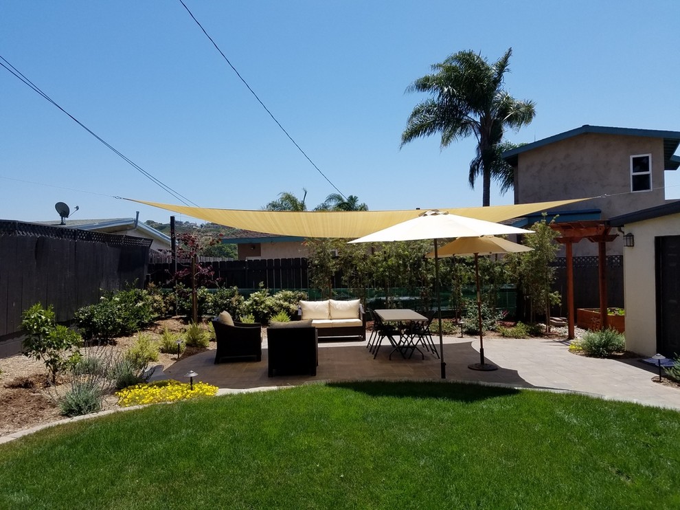 Large classic back patio in San Diego with concrete paving and an awning.