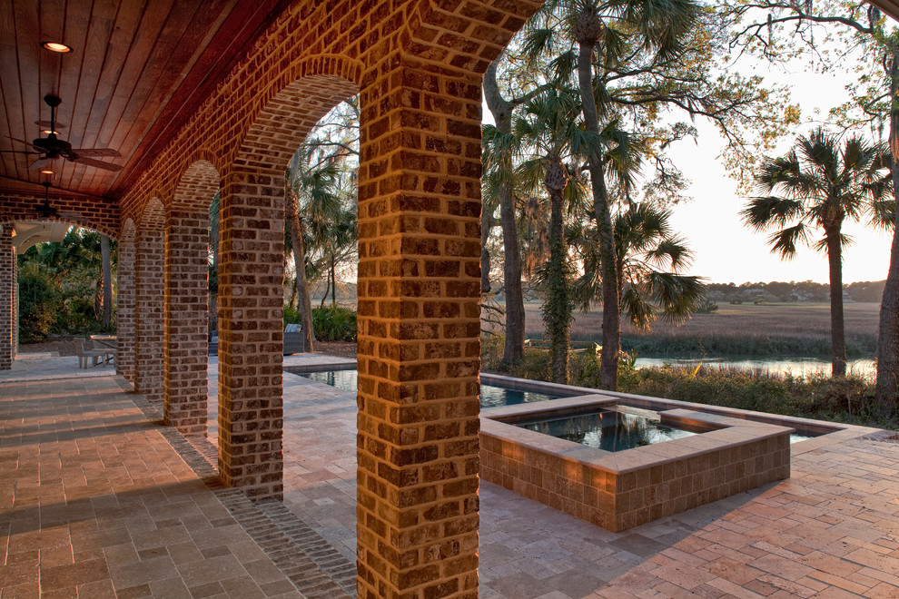 This is an example of a large nautical back patio in Charleston with a water feature and a pergola.