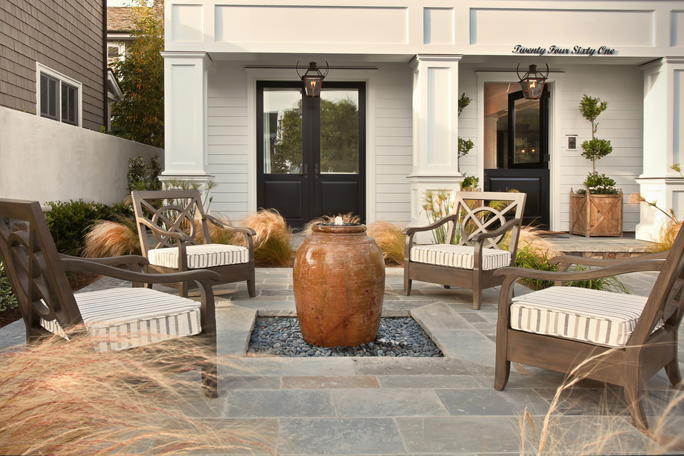Design ideas for a beach style front patio in Orange County with a water feature.