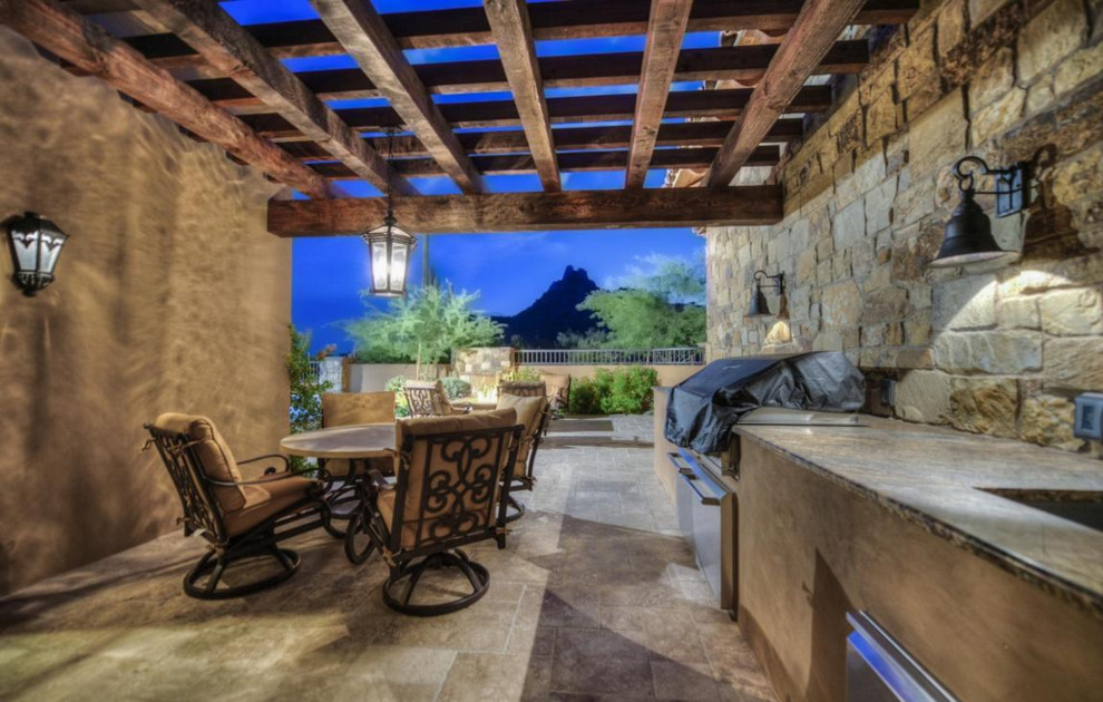 Huge backyard stone patio photo in Phoenix with a roof extension