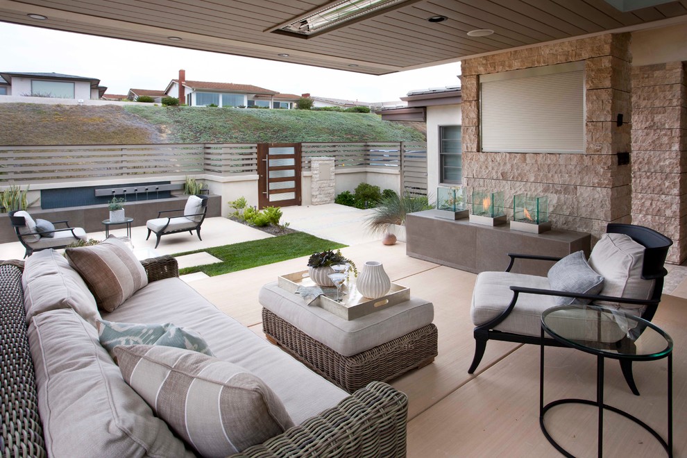 Exemple d'une terrasse tendance avec un foyer extérieur.