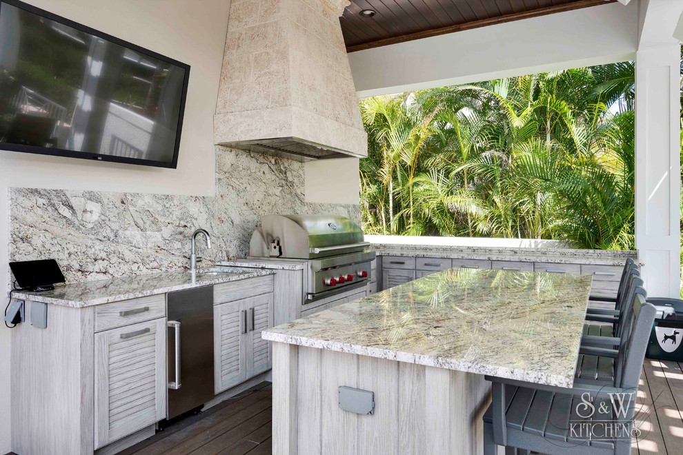 Cette image montre une terrasse en bois arrière marine de taille moyenne avec une cuisine d'été et une extension de toiture.