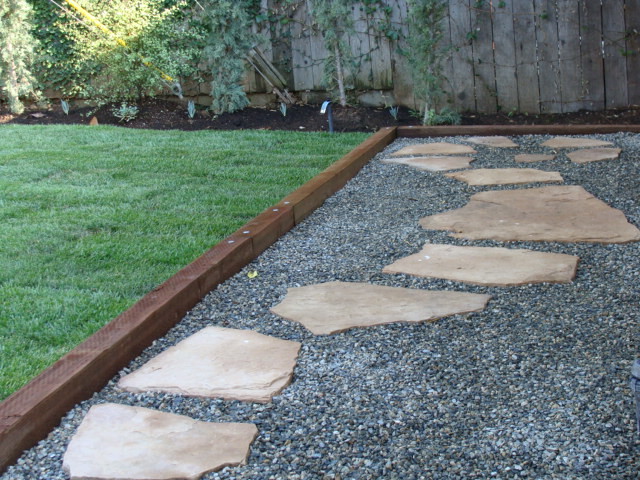 Inspiration for a coastal backyard stone patio remodel in Orange County with a roof extension